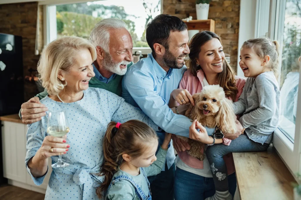 Cheerful multi generation family with dog having fun while spending time together home